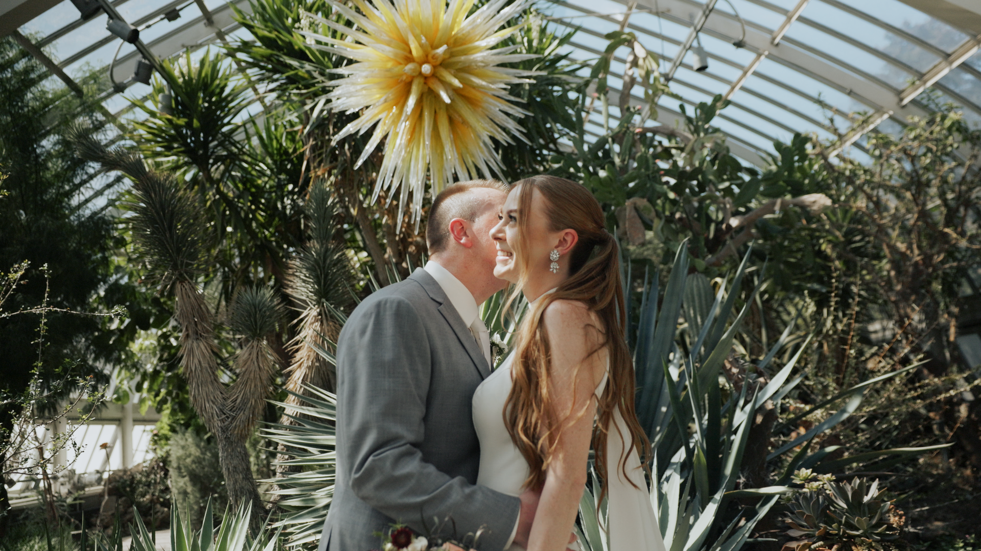 a young couple taking wedding portraits at phipps conservatory in the Desert Room in front of the Golden star