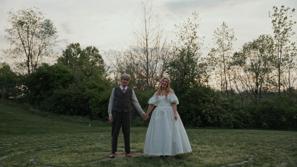 sunset portrait of the couple at their wedding at the rivers of steel pump house. the couple is holding hands and looking at the camera